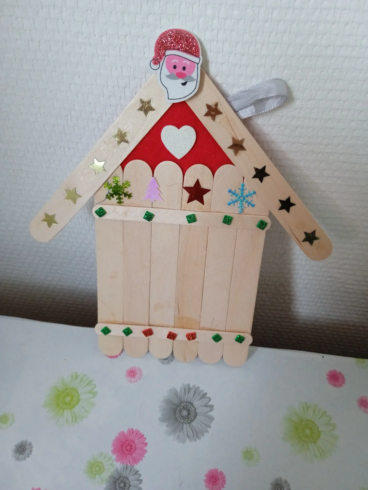 Petite maison de Noël en bâtonnets de bois, réalisée lors d’une rencontre