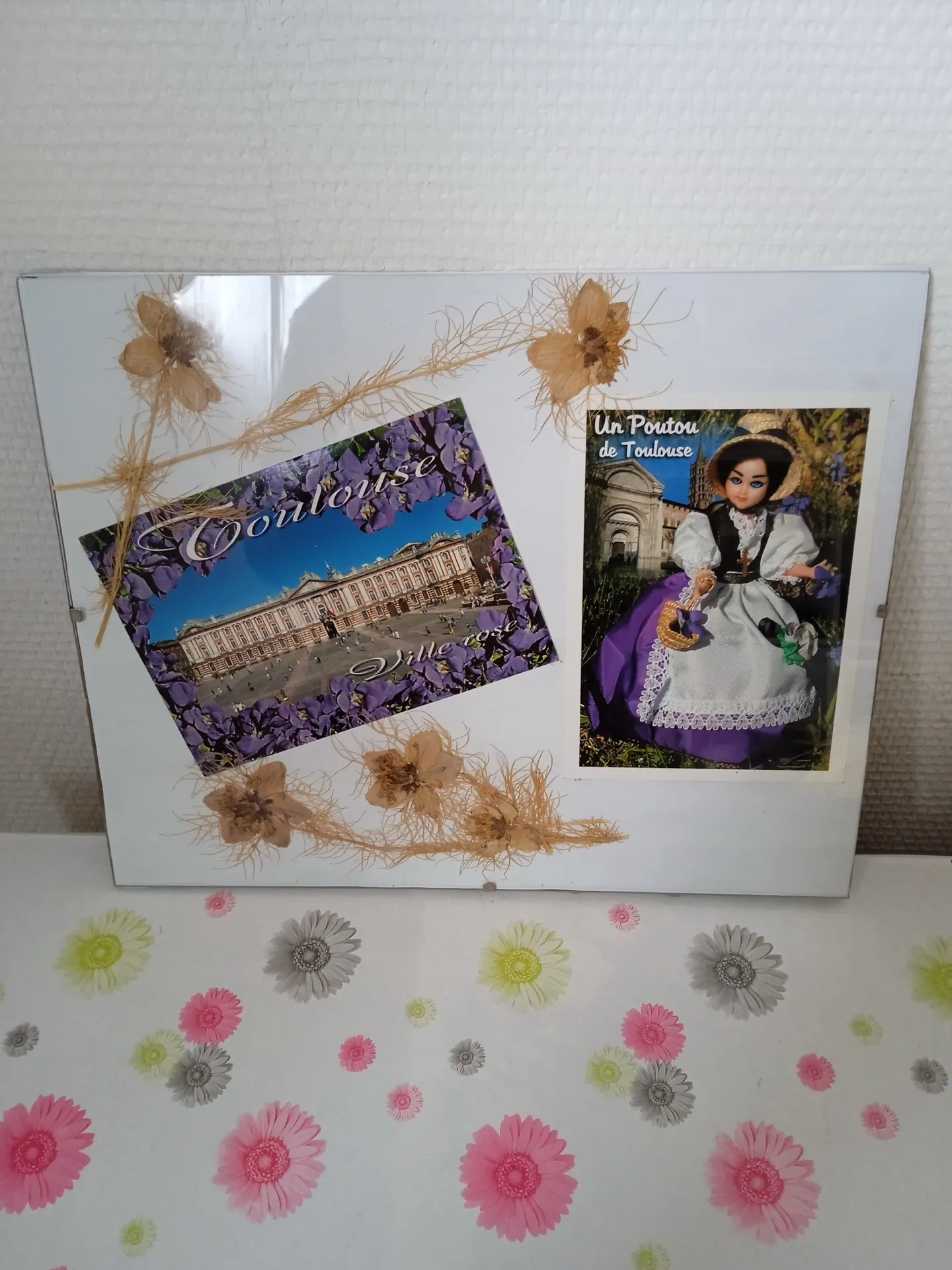 Composition décorée de cartes postales de Toulouse et d’une poupée en costume traditionnel
