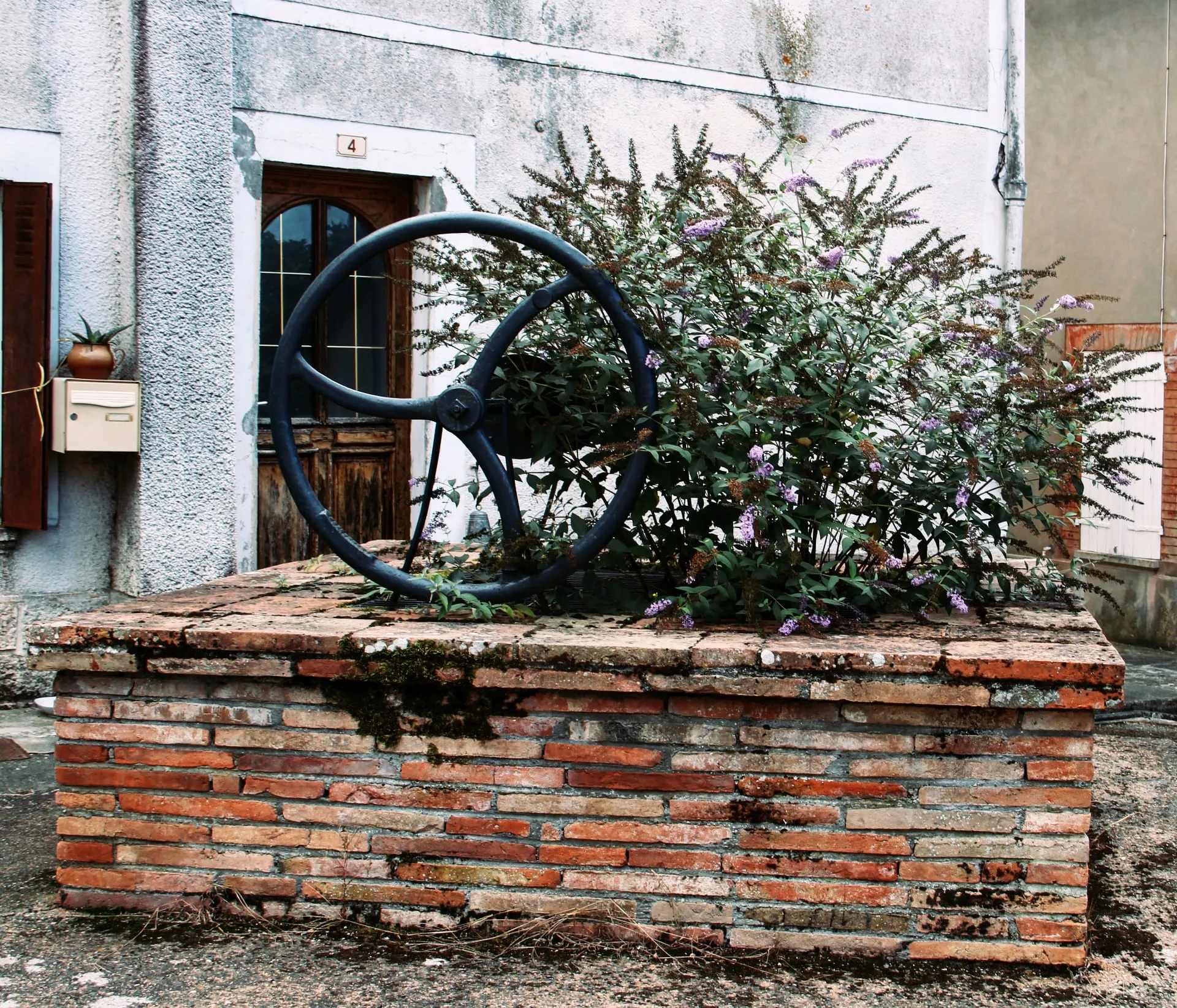 Le vieux puits de Cadours, devant une façade du village